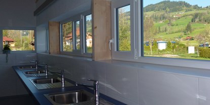 Campingplätze - Grillen mit Holzkohle möglich - Der Spülbereich mit Panoramablick auf den Stoffelberg.  - Camping Zeh am See/ Allgäu