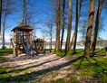 Campingplatz: naturbelassener Spielplatz mit hohen Bäumen, direkt am See - Camping Stein